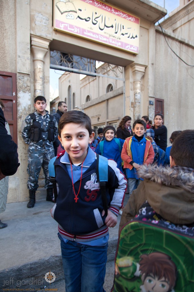 A member of the Sootoro is seen in the background providing protection for the students as they leave school. The Picture Christians Project/Jeff Gardner