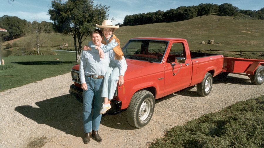 February 1985: A full-length portrait of United States president Ronald Reagan and First Lady Nancy Reagan, who is sitting on the hood of a red 1985 Ford Ranger pick-up truck with her arms around her husband, at their ranch (Rancho del Cielo) near Santa Barbara, California.